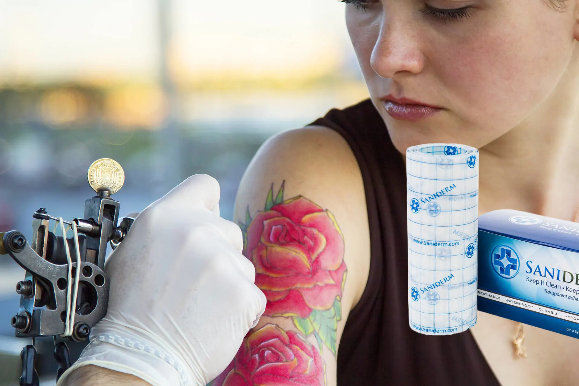 Woman having rose tattoo applied with a tattoo gun Woman having rose tattoo applied with a tattoo gun